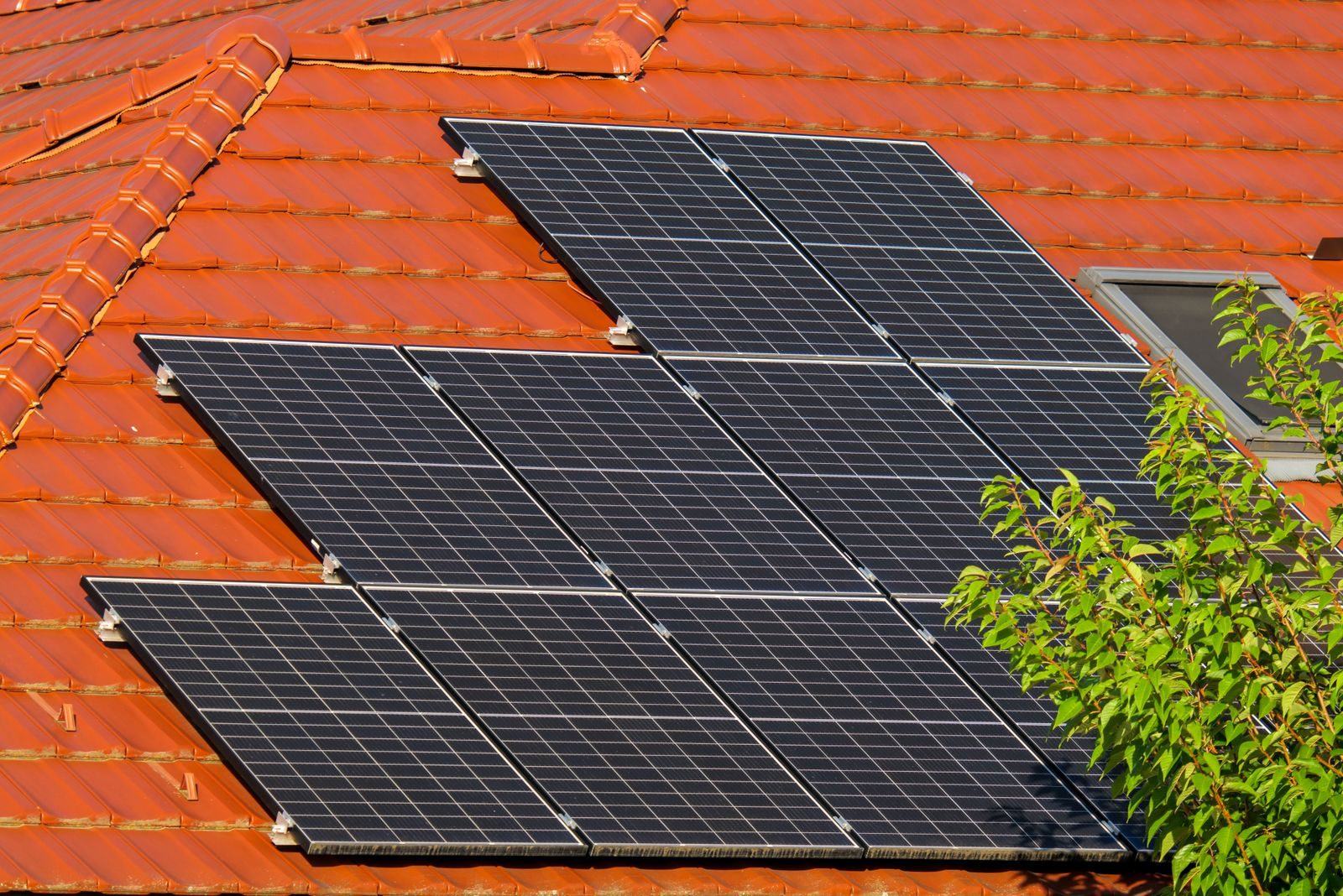 Painéis solares instalados sobre telhado de telha cerâmica d Painéis solares instalados sobre telhado de telha cerâmica de uma casa